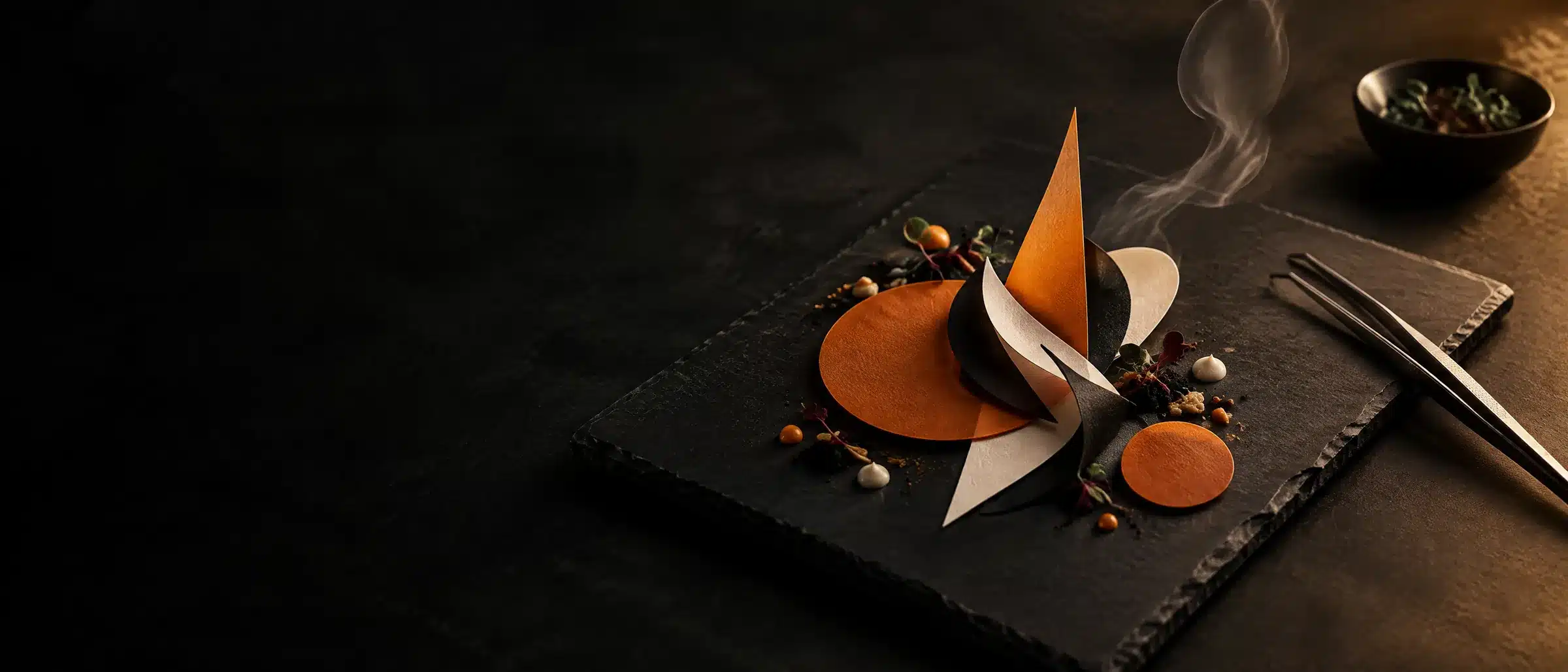 Cut-paper logo shapes plated on slate like a finished dish